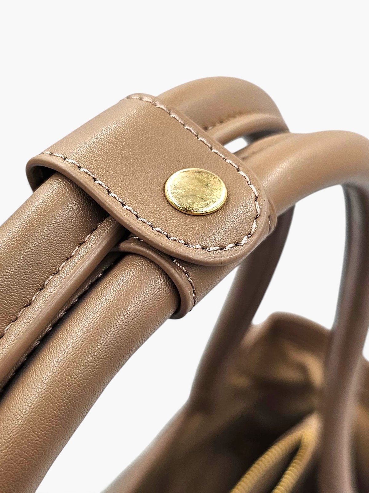 Close-up of the gold-coloured stud clasp on The.KTP's handle